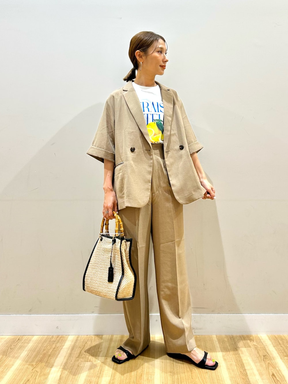 ベージュ系のテーラードジャケット、ベージュ系のその他パンツ、ホワイト系のTシャツ/カットソーを着用したレディースの夏コーディネートの2枚目の写真
