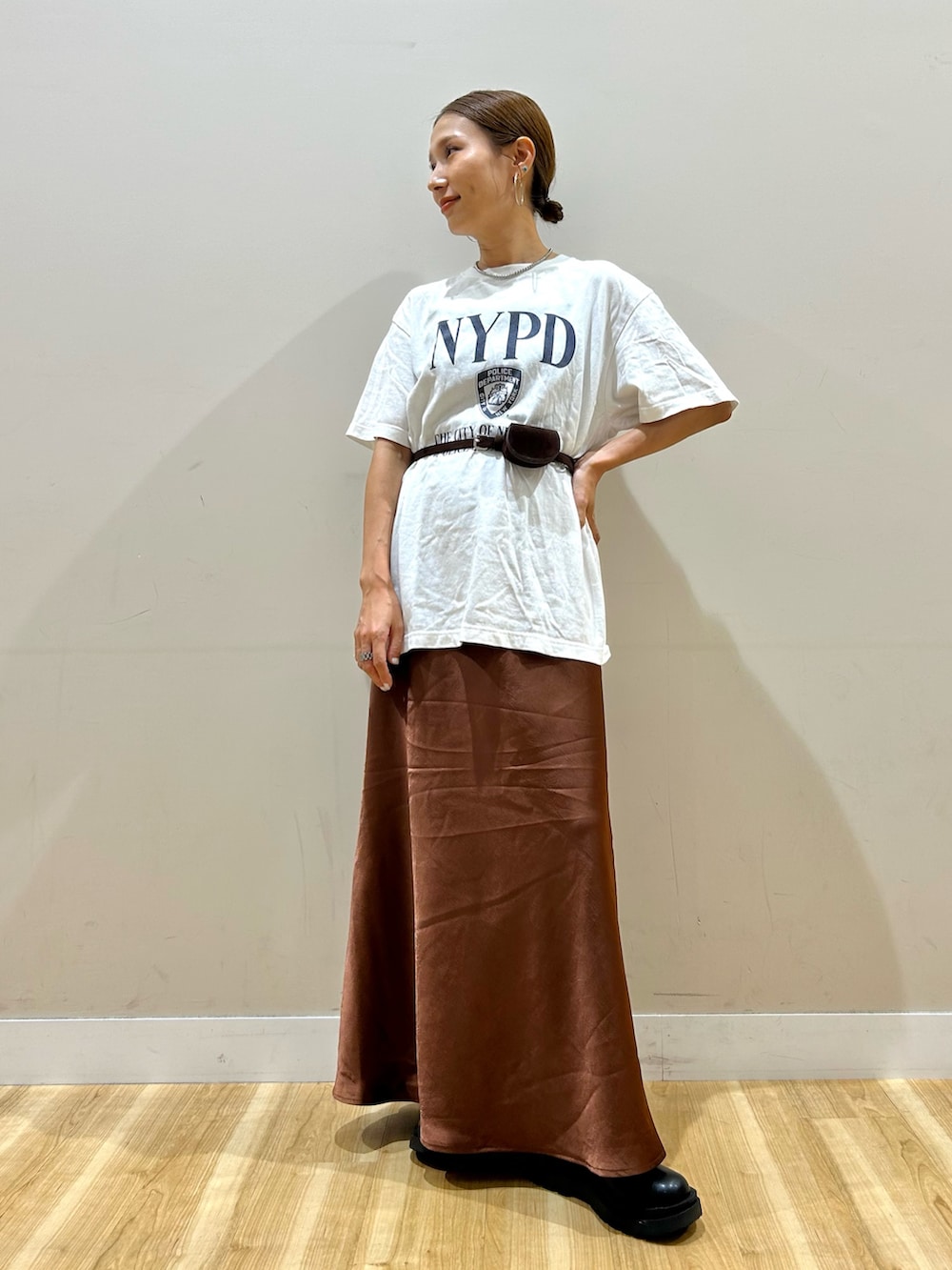 ホワイト系のTシャツ/カットソー、ブラウン系のスカート、ブラック系のブーツを着用したレディースの夏コーディネートの4枚目の写真