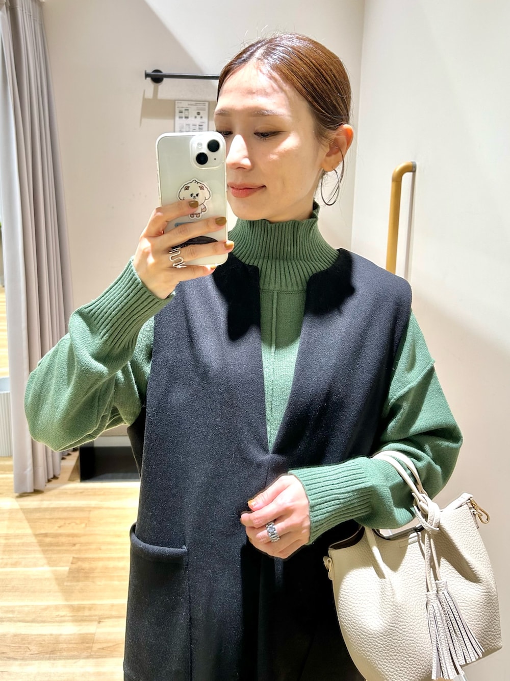 グレー系のその他アウター、グリーン系のニット/セーター、ブラック系のジャンパースカートを着用したレディースの冬コーディネートの9枚目の写真