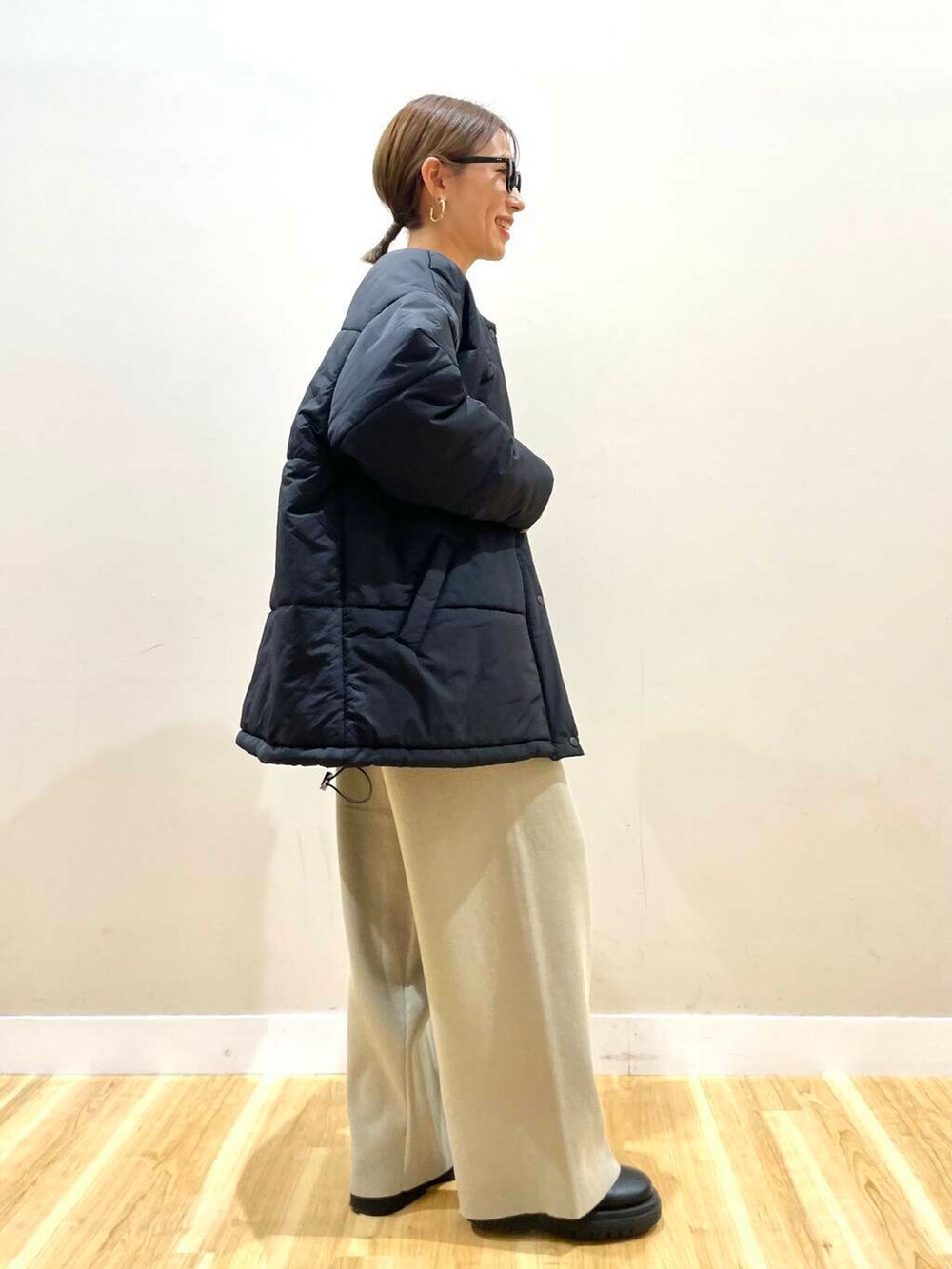 ホワイト系のニット/セーター、ブラック系のダウンジャケット/コート、ベージュ系のその他パンツを着用したレディースの冬コーディネートの3枚目の写真