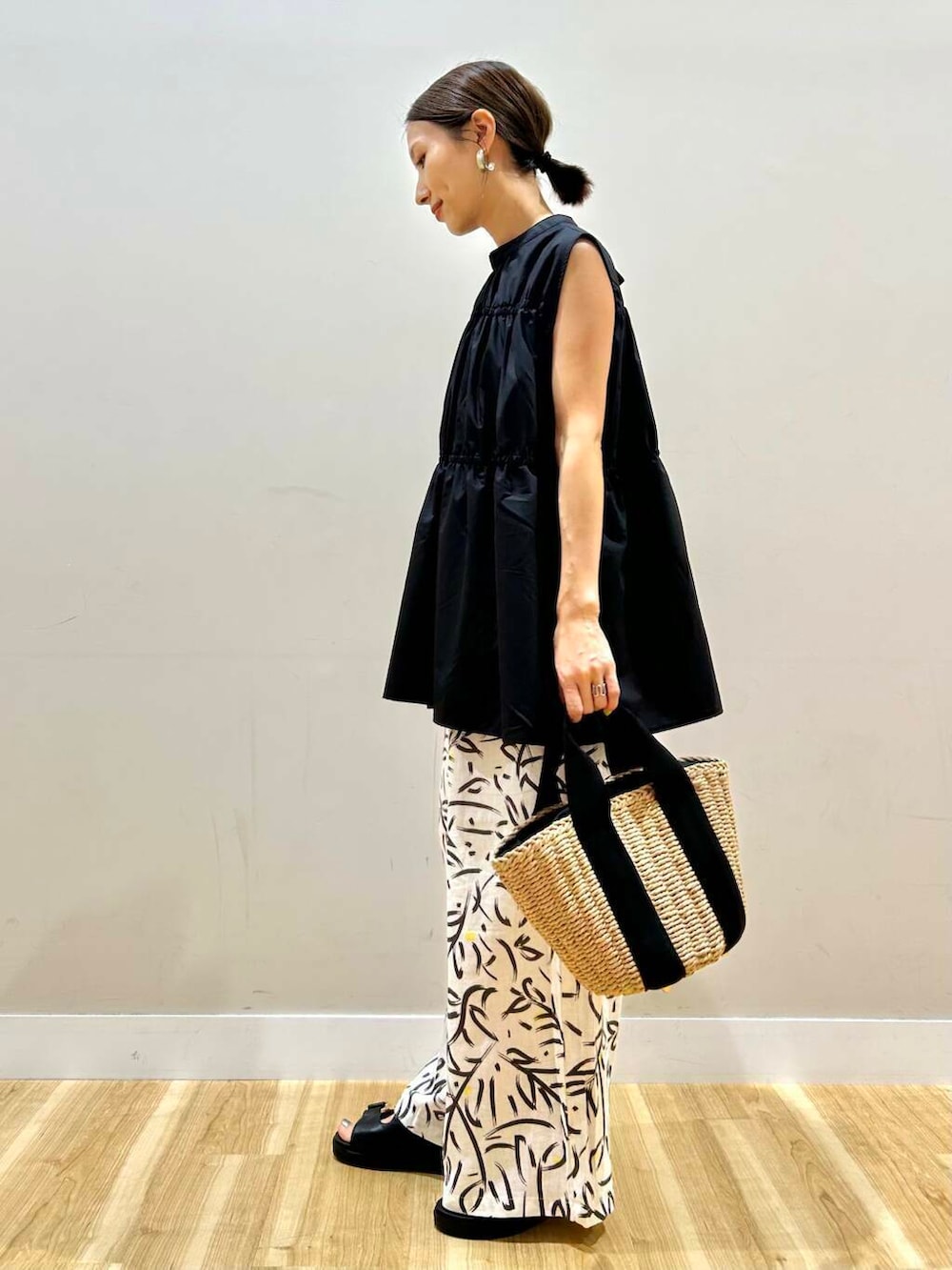 ホワイト系のその他パンツ、ベージュ系のハンドバッグ、ブラック系のサンダルを着用したレディースの夏コーディネートの2枚目の写真