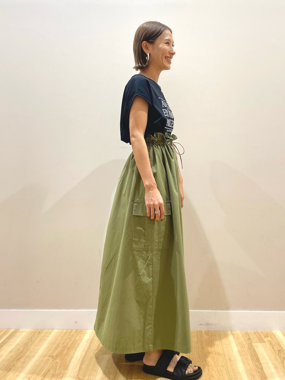 ブラック系のTシャツ/カットソー、グリーン系のスカートを着用したレディースの夏コーディネートの2枚目の写真