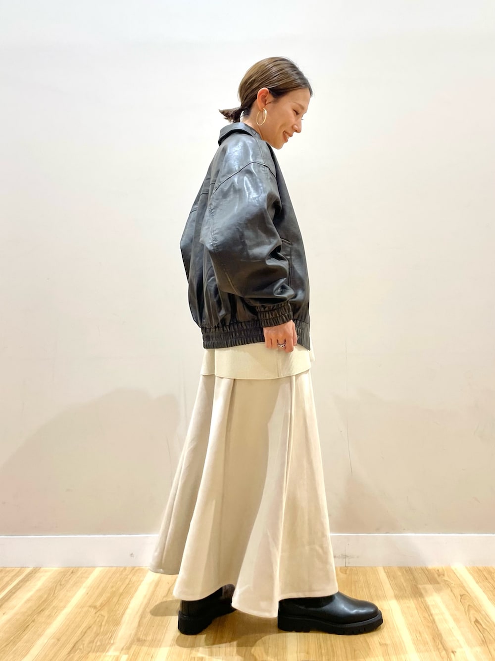 ブラウン系のその他アウター、ホワイト系のニット/セーター、ベージュ系のスカートを着用したレディースの秋コーディネートの2枚目の写真