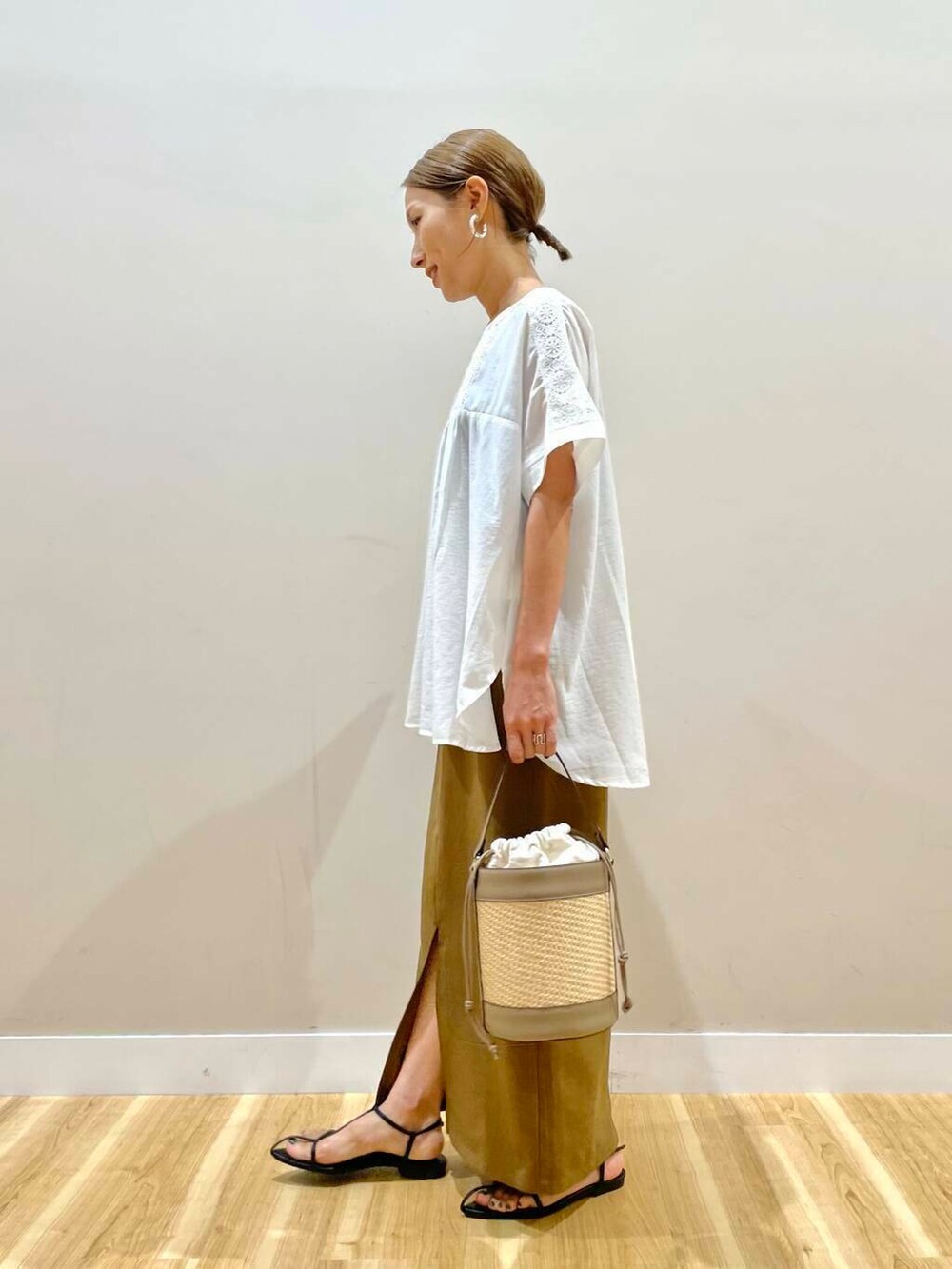 ホワイト系のシャツ/ブラウス、グレー系のショルダーバッグ、イエロー系のスカートを着用したレディースの夏コーディネートの4枚目の写真