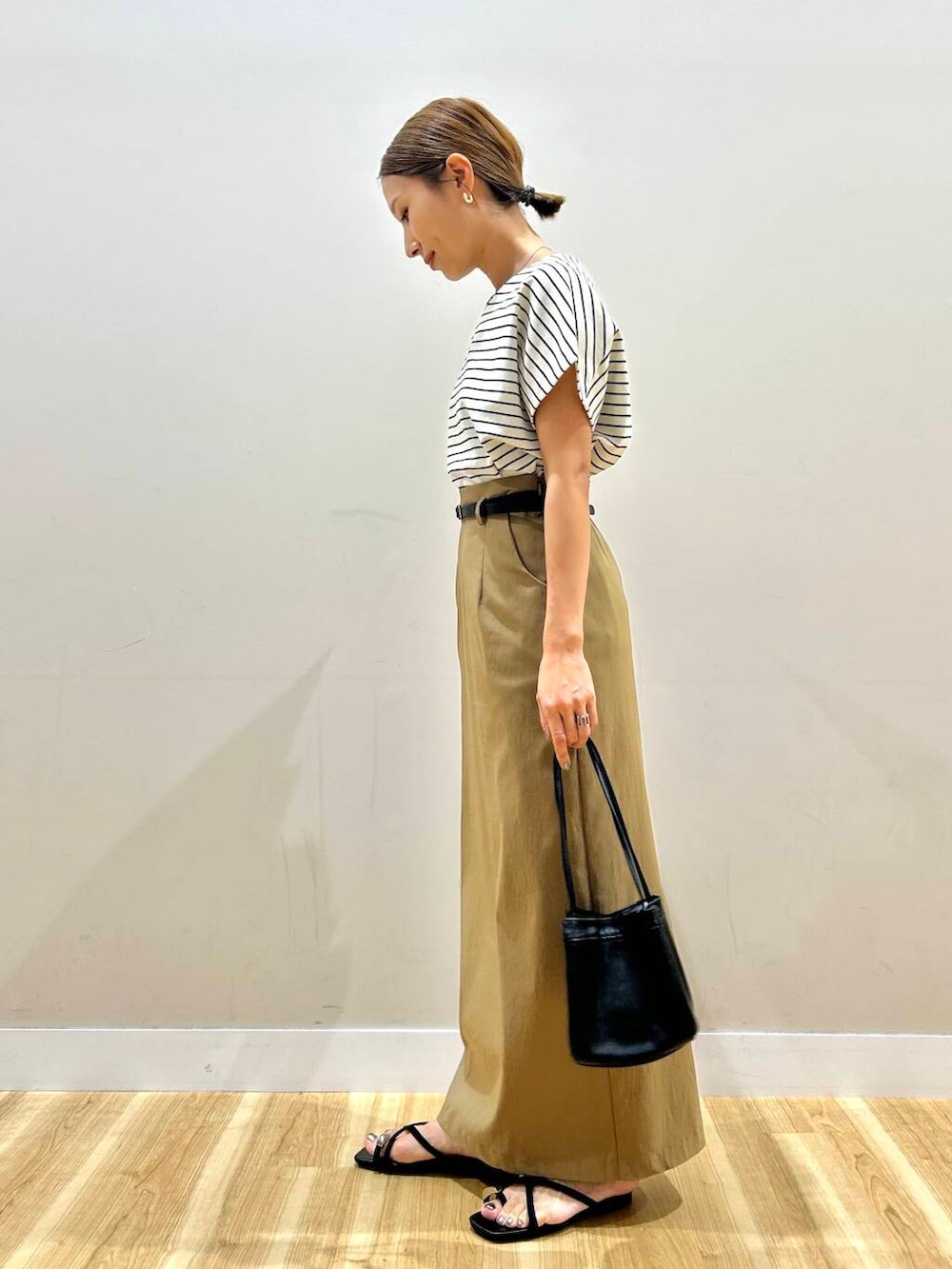 ホワイト系のTシャツ/カットソー、ブラック系のハンドバッグ、イエロー系のスカートを着用したレディースの夏コーディネートの2枚目の写真