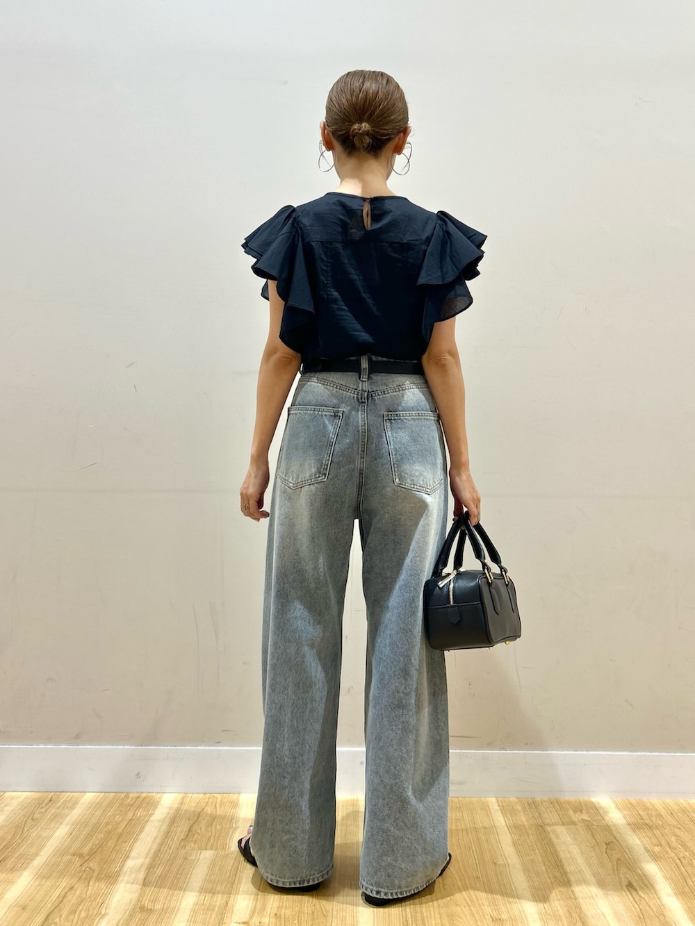 ブラック系のシャツ/ブラウス、ブルー系のデニムパンツ、ブラック系のサンダルを着用したレディースの夏コーディネートの3枚目の写真