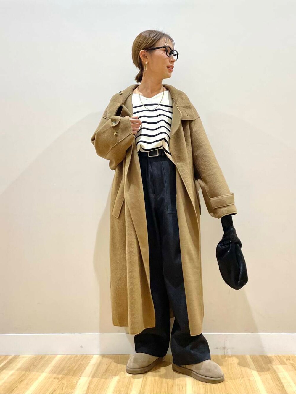 ブラック系のハンドバッグ、ブラック系のニット/セーター、ブラック系のデニムパンツを着用したレディースの秋コーディネートの7枚目の写真