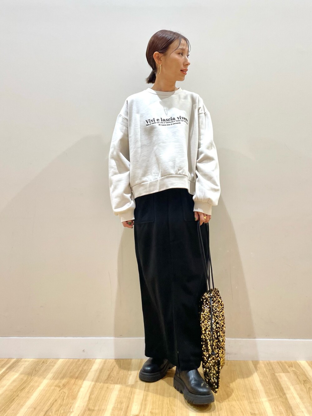 ブラウン系のブルゾン、ホワイト系のTシャツ/カットソー、ブラック系のスカートを着用したレディースの冬コーディネートの4枚目の写真