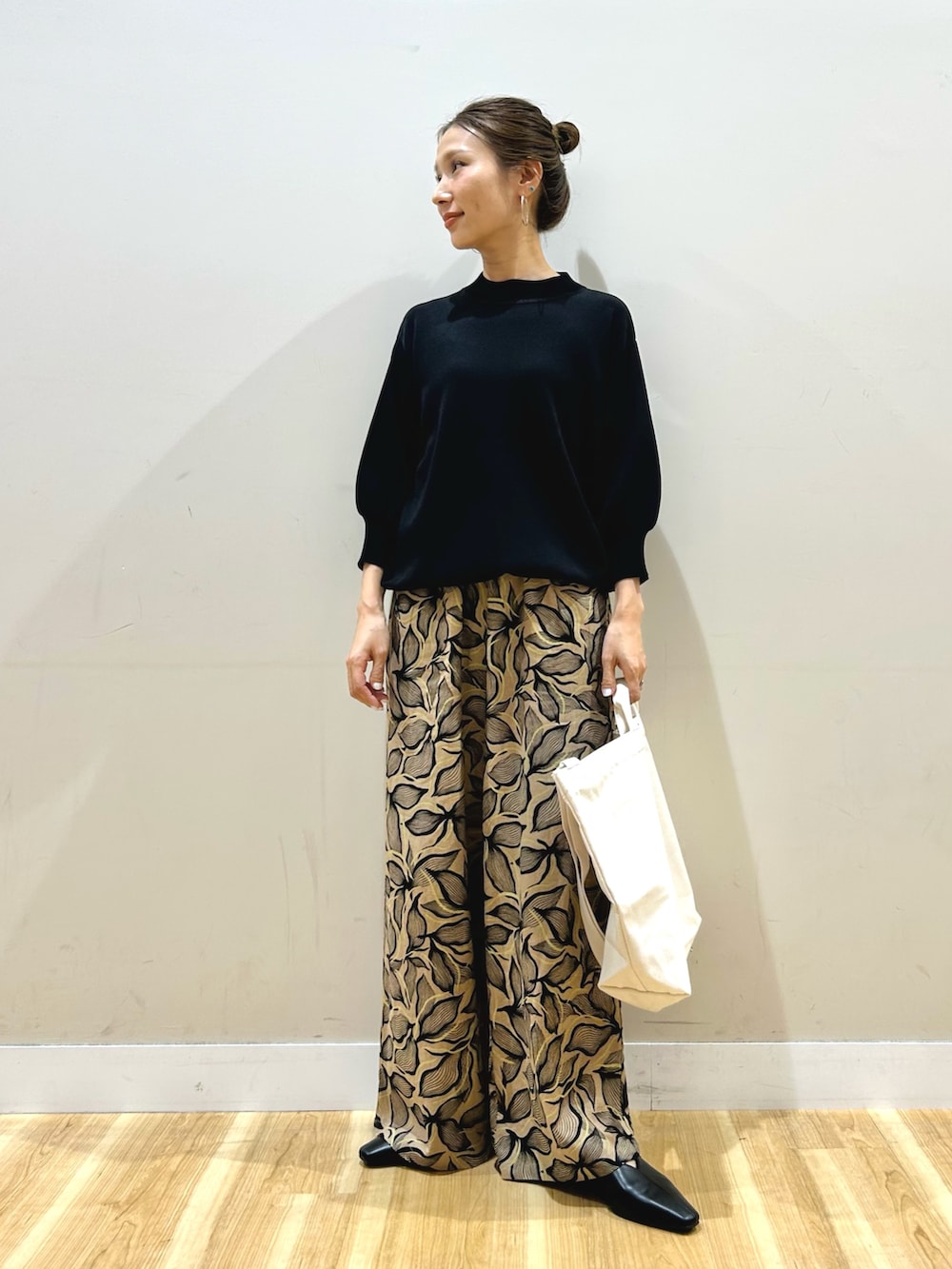 ブラック系のマウンテンパーカー、ブラック系のニット/セーター、ブラウン系のその他パンツを着用したレディースの春コーディネートの4枚目の写真