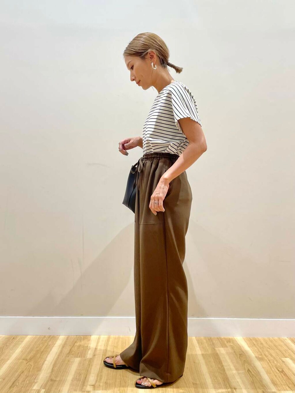 ブラウン系のサンダル、ホワイト系のTシャツ/カットソー、ブラック系のトートバッグを着用したレディースの夏コーディネートの4枚目の写真