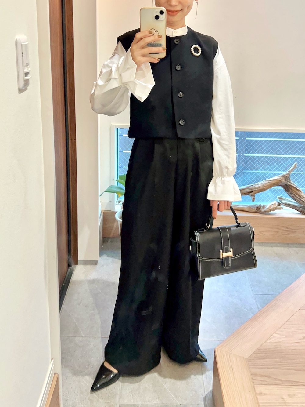 ホワイト系のシャツ/ブラウス、ブラック系のパンプス、ゴールド系のピアス（両耳用）を着用したレディースの春コーディネートの2枚目の写真