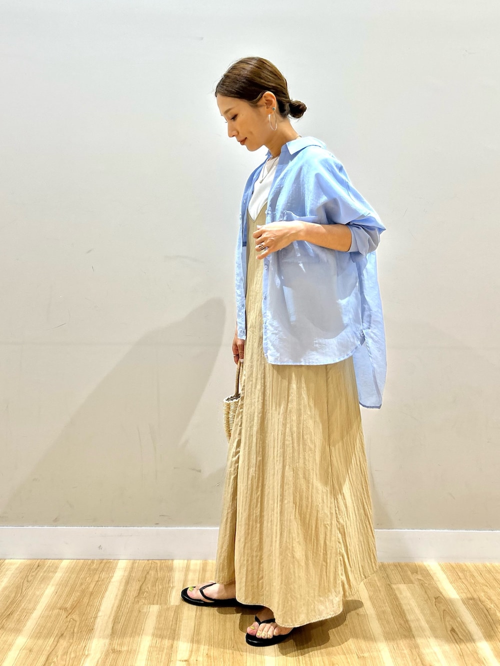 ブルー系のシャツ/ブラウス、ベージュ系のワンピース、グレー系のハンドバッグを着用したレディースの夏コーディネートの2枚目の写真