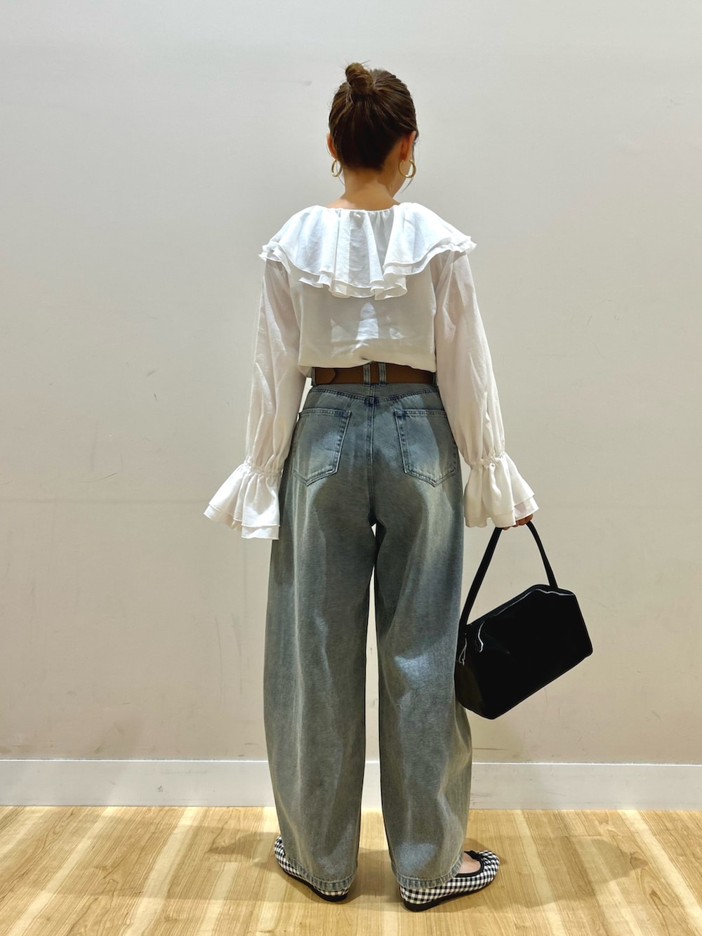 ホワイト系のシャツ/ブラウス、ブルー系のデニムパンツ、ブラック系のトートバッグを着用したレディースの春コーディネートの4枚目の写真