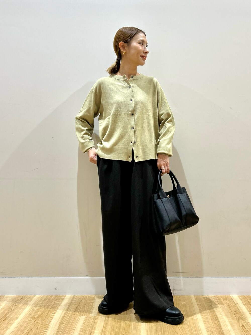 ブラック系のダウンジャケット/コート、グリーン系のカーディガン/ボレロ、ブラウン系のその他パンツを着用したレディースの秋コーディネートの5枚目の写真