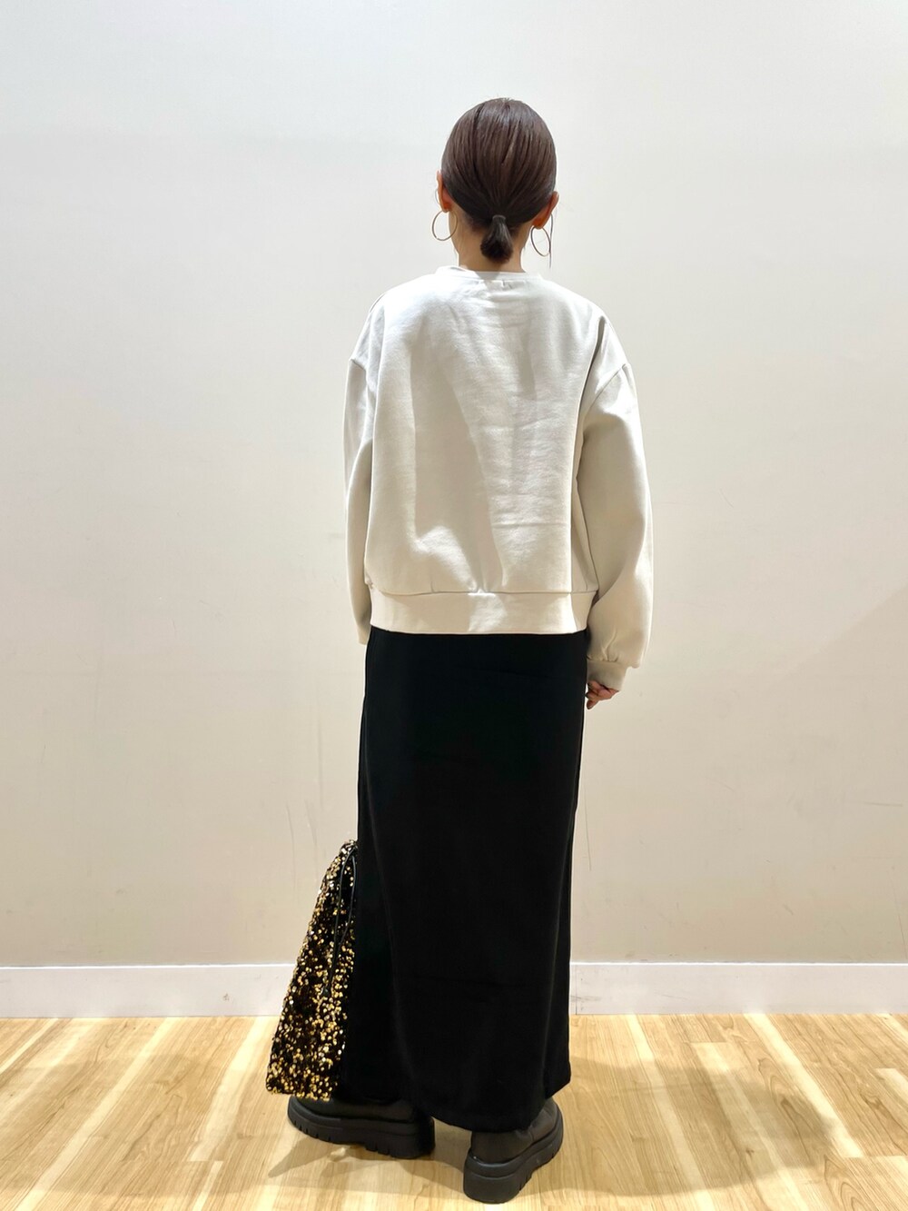 ブラウン系のブルゾン、ホワイト系のTシャツ/カットソー、ブラック系のスカートを着用したレディースの冬コーディネートの6枚目の写真