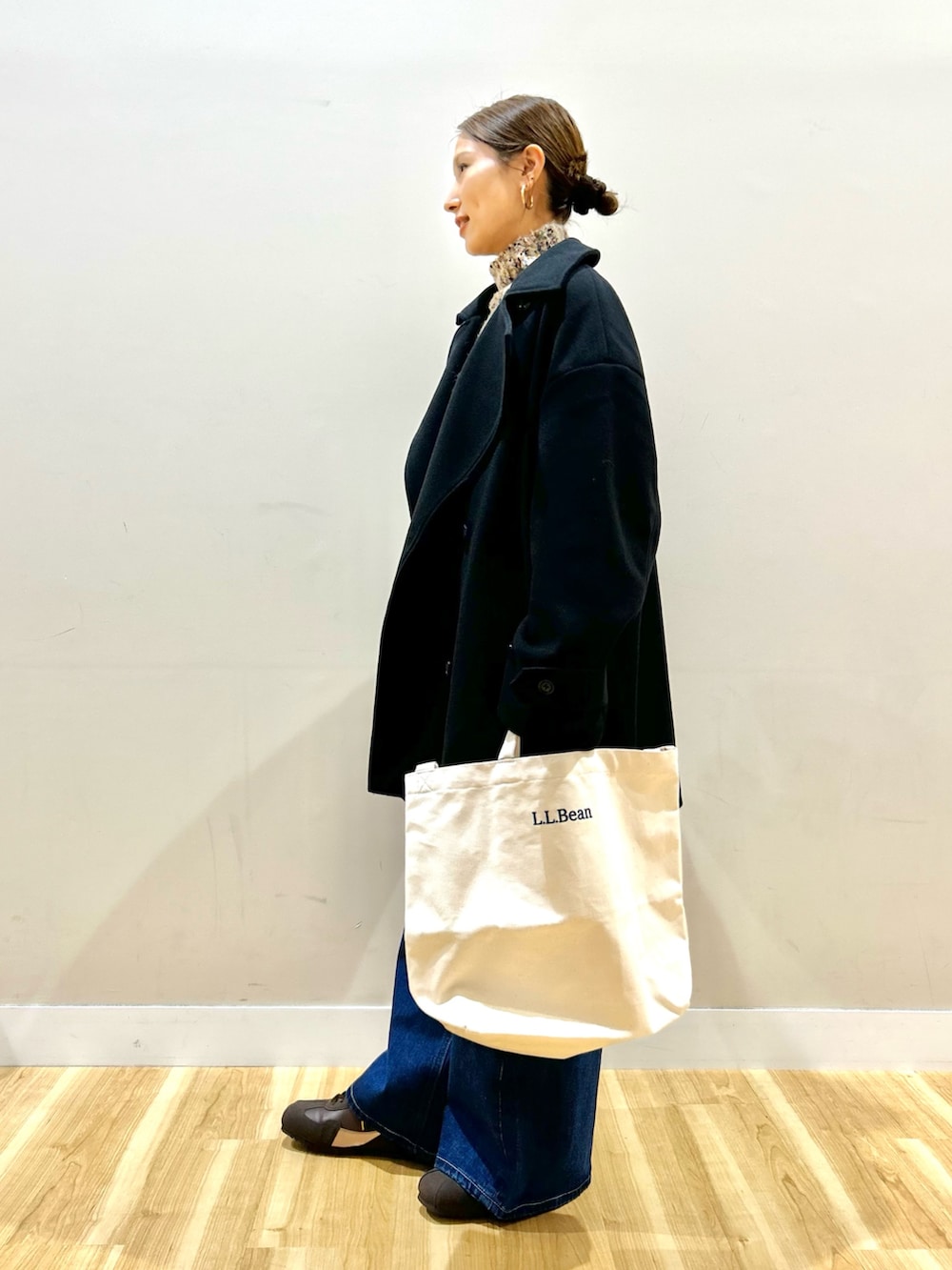 ブラック系のその他アウター、ベージュ系のニット/セーター、ブラウン系のスニーカーを着用したレディースの冬コーディネートの2枚目の写真