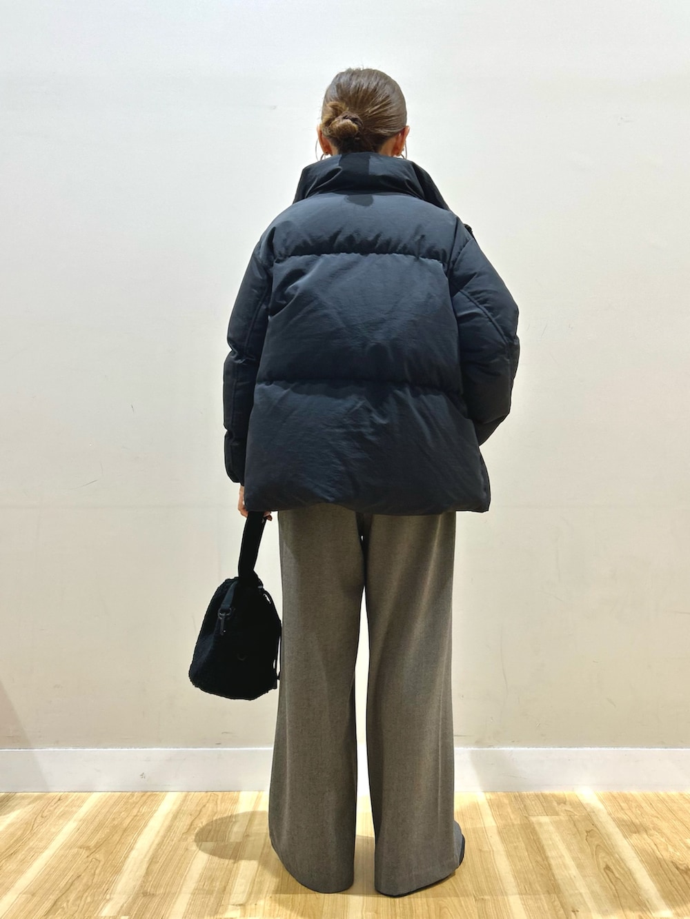 ブラック系のダウンジャケット/コート、ホワイト系のTシャツ/カットソー、ブラック系のブーツを着用したレディースの冬コーディネートの3枚目の写真