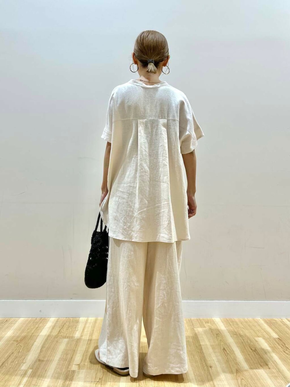 ベージュ系のその他パンツ、ベージュ系のシャツ/ブラウス、ブラック系のショルダーバッグを着用したレディースの夏コーディネートの3枚目の写真