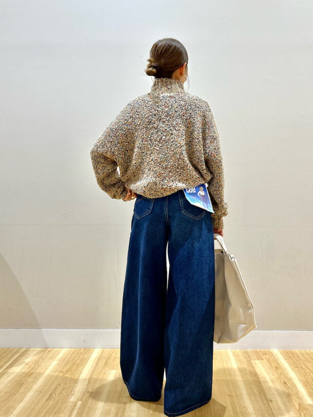 ブラック系のその他アウター、ベージュ系のニット/セーター、ブラウン系のスニーカーを着用したレディースの冬コーディネートの6枚目の写真