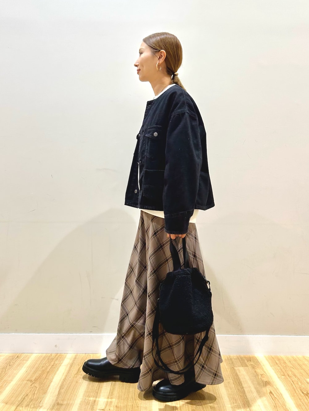 ブラック系のデニムジャケット、ホワイト系のスウェット、ブラウン系のスカートを着用したレディースの秋コーディネートの2枚目の写真