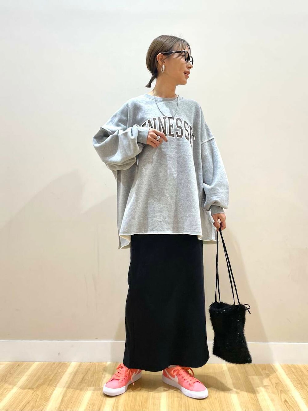 ピンク系のスニーカー、グレー系のスウェット、ブラック系のハンドバッグを着用したレディースの秋コーディネートの5枚目の写真