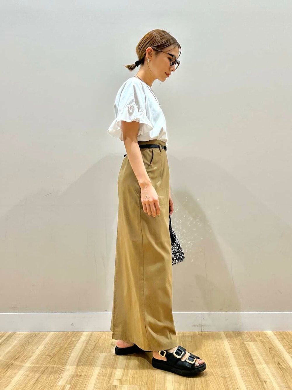 シルバー系のショルダーバッグ、ブラック系のサンダル、ホワイト系のTシャツ/カットソーを着用したレディースの春コーディネートの5枚目の写真