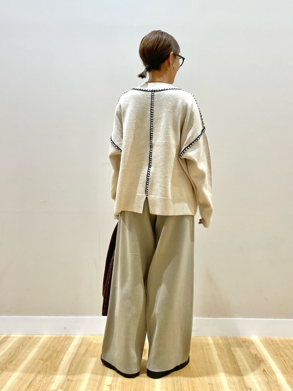 ブラック系のダウンジャケット/コート、ホワイト系のニット/セーター、ベージュ系のその他パンツを着用したレディースの冬コーディネートの6枚目の写真