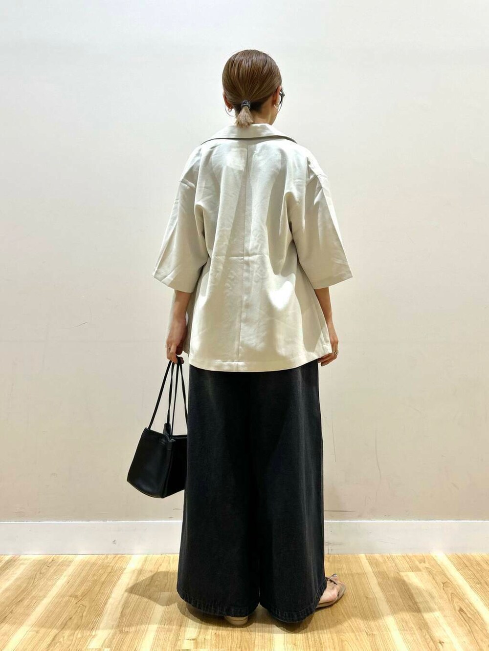 グレー系のサンダル、ブラック系のデニムパンツ、ベージュ系のその他アウターを着用したレディースの春コーディネートの5枚目の写真