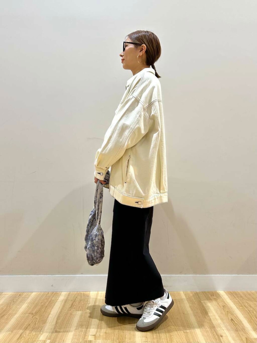 グレー系のハンドバッグ、ブラック系のニット/セーター、ブラック系のスカートを着用したレディースの冬コーディネートの5枚目の写真