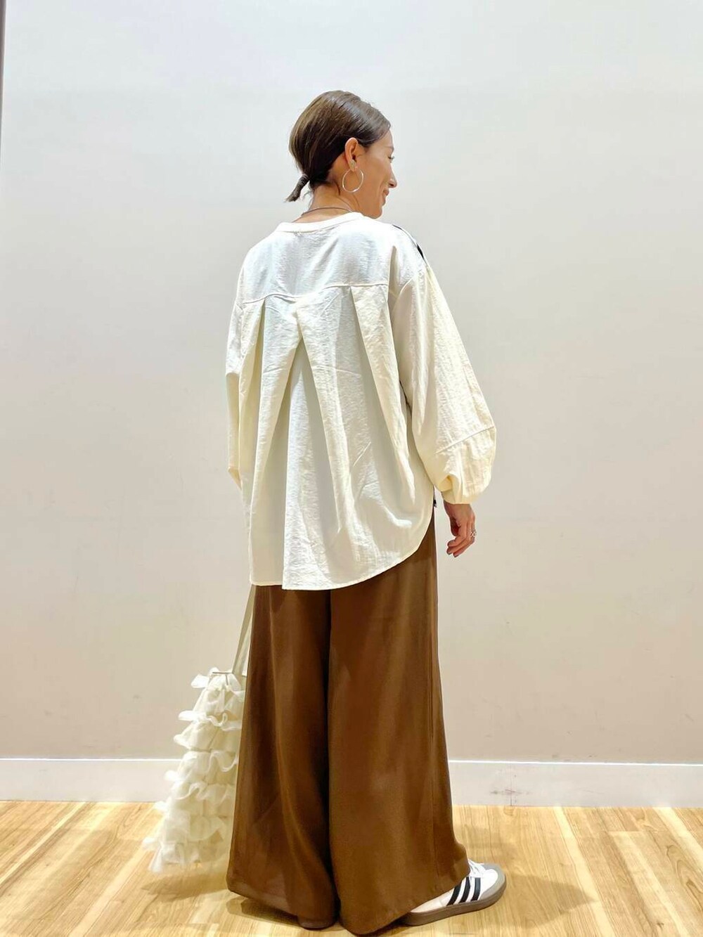 ホワイト系のトートバッグ、ホワイト系のTシャツ/カットソー、ブラウン系のその他パンツを着用したレディースの秋コーディネートの3枚目の写真