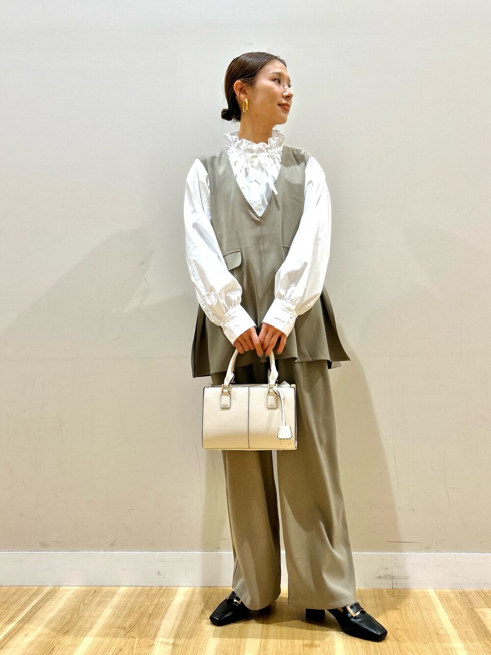 ベージュ系のセットアップ、ホワイト系のハンドバッグ、ホワイト系のシャツ/ブラウスを着用したレディースの冬コーディネートの4枚目の写真