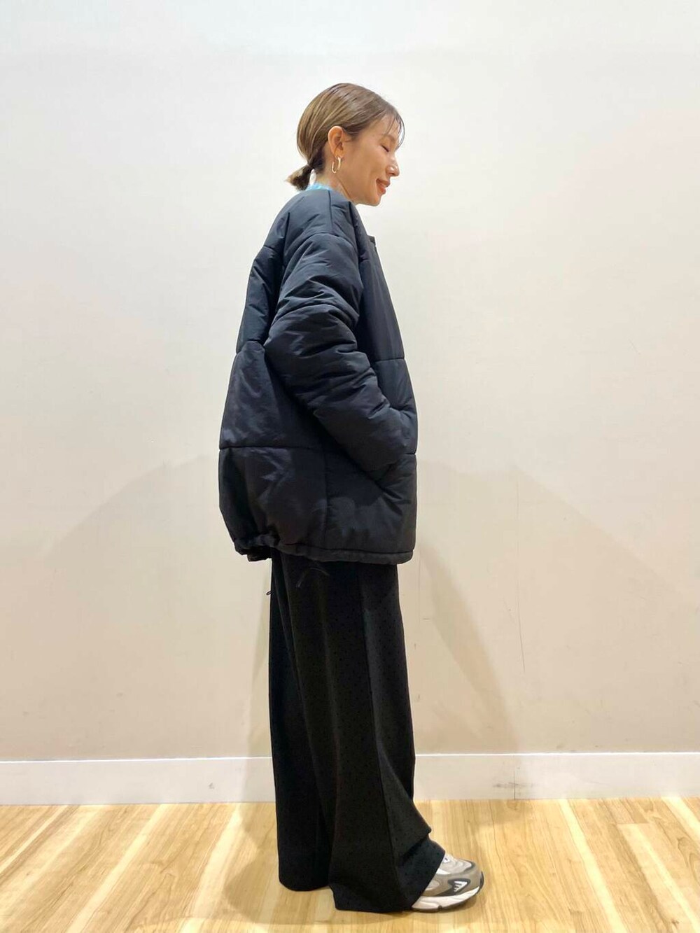 ブラック系のダウンジャケット/コート、ブルー系のニット/セーター、グレー系のハンドバッグを着用したレディースの冬コーディネートの6枚目の写真