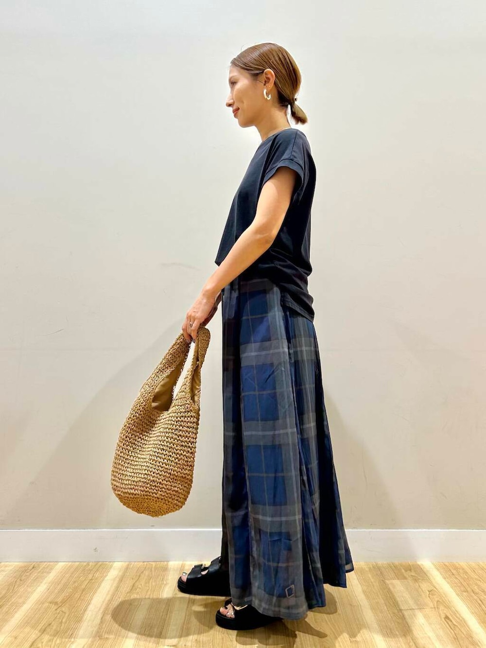 ブラック系のサンダル、イエロー系のトートバッグ、ブルー系のスカートを着用したレディースの夏コーディネートの4枚目の写真