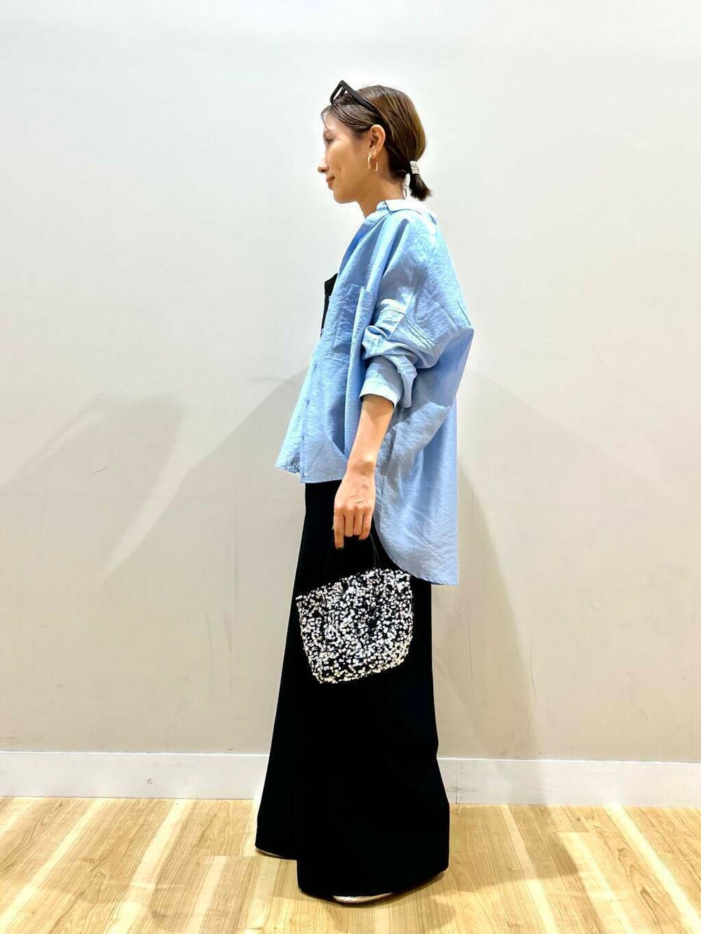 ブルー系のシャツ/ブラウス、シルバー系のショルダーバッグ、ブラック系のサロペット/オーバーオールを着用したレディースの春コーディネートの4枚目の写真
