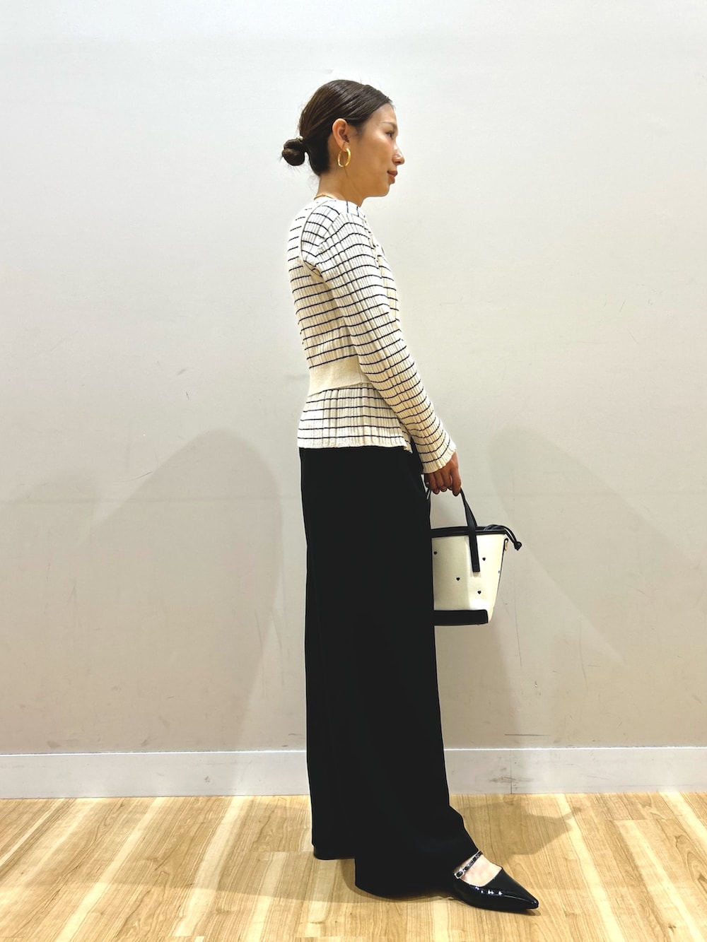 ブラウン系のその他アウター、ホワイト系のニット/セーター、ブラック系のその他パンツを着用したレディースの春コーディネートの6枚目の写真