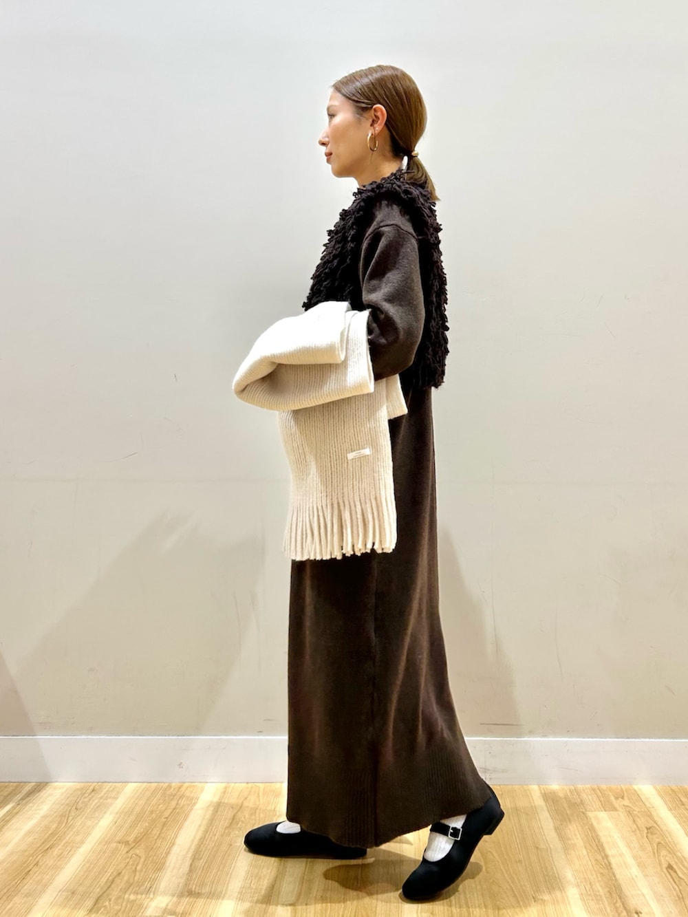 ブラウン系のワンピース、ホワイト系のショルダーバッグ、ブラック系のパンプスを着用したレディースの秋コーディネートの2枚目の写真