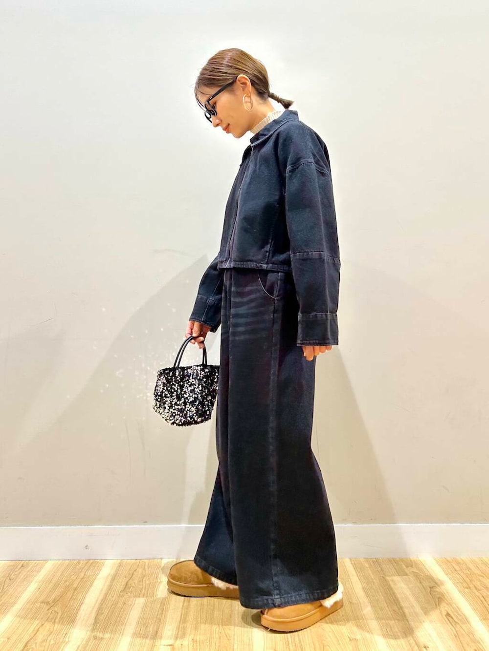 ホワイト系のニット/セーター、シルバー系のショルダーバッグ、ブラック系のデニムパンツを着用したレディースの冬コーディネートの2枚目の写真