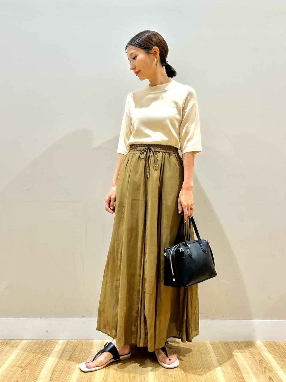 ホワイト系のニット/セーター、ブラウン系のスカートを着用したレディースの夏コーディネートの2枚目の写真