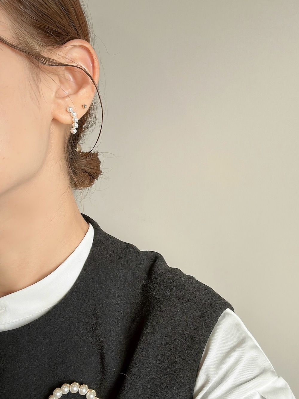 ホワイト系のシャツ/ブラウス、ブラック系のパンプス、ゴールド系のピアス（両耳用）を着用したレディースの春コーディネートの3枚目の写真