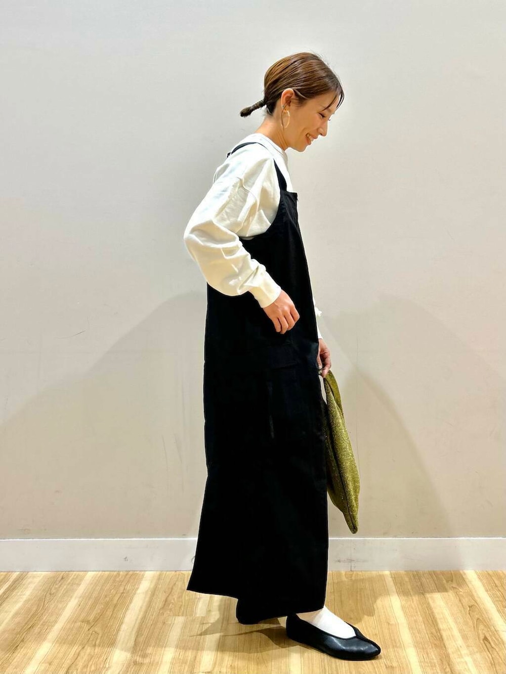 ゴールド系のトートバッグ、ベージュ系のマウンテンパーカー、ホワイト系のスウェットを着用したレディースの冬コーディネートの7枚目の写真