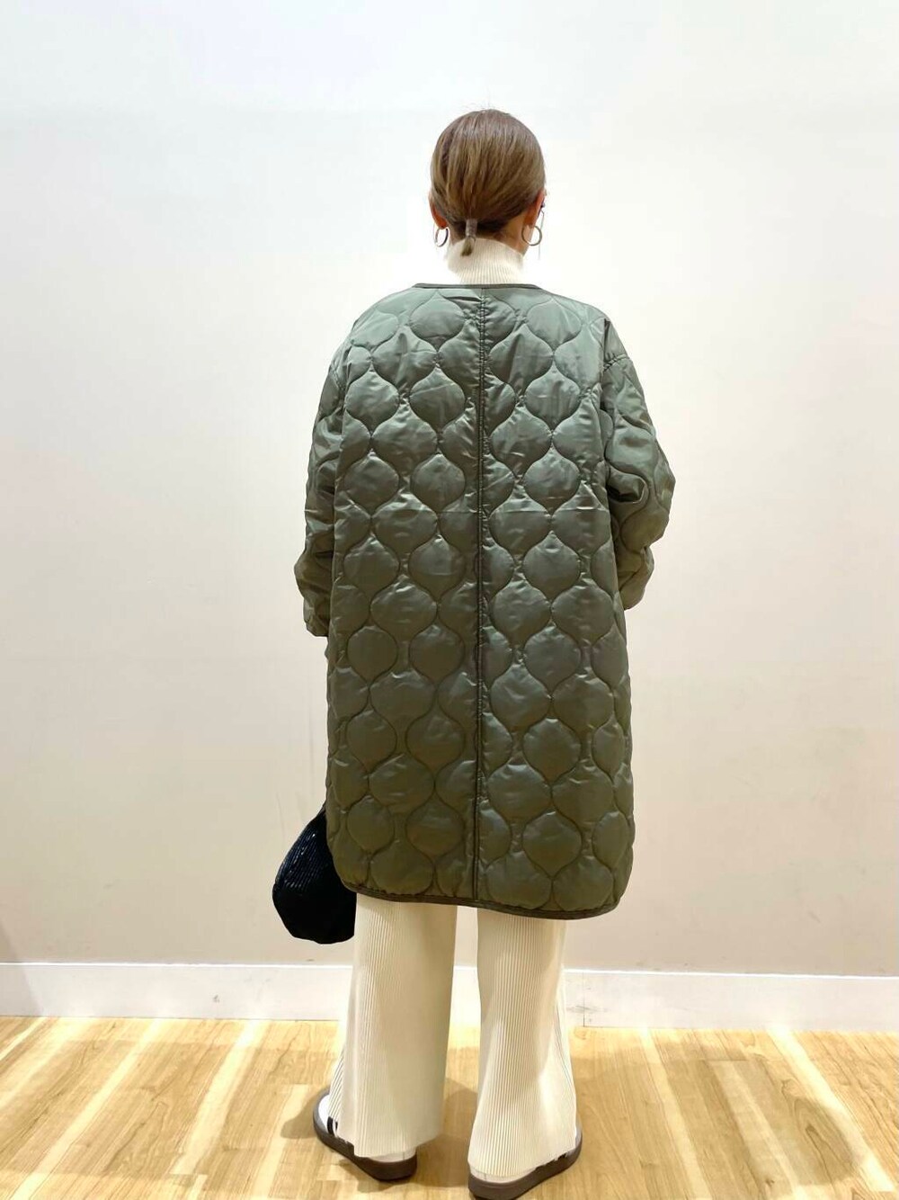 ホワイト系のその他パンツ、ブラック系のハンドバッグ、グリーン系のその他アウターを着用したレディースの冬コーディネートの4枚目の写真