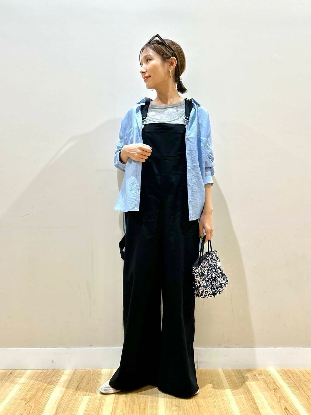 ブルー系のシャツ/ブラウス、シルバー系のショルダーバッグ、ブラック系のサロペット/オーバーオールを着用したレディースの春コーディネートの6枚目の写真