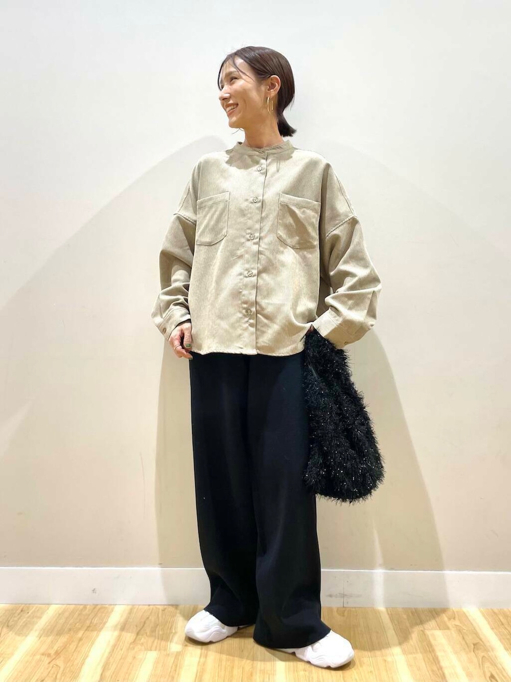 ホワイト系のスニーカー、ベージュ系のTシャツ/カットソー、ブラック系のダウンジャケット/コートを着用したレディースの冬コーディネートの9枚目の写真