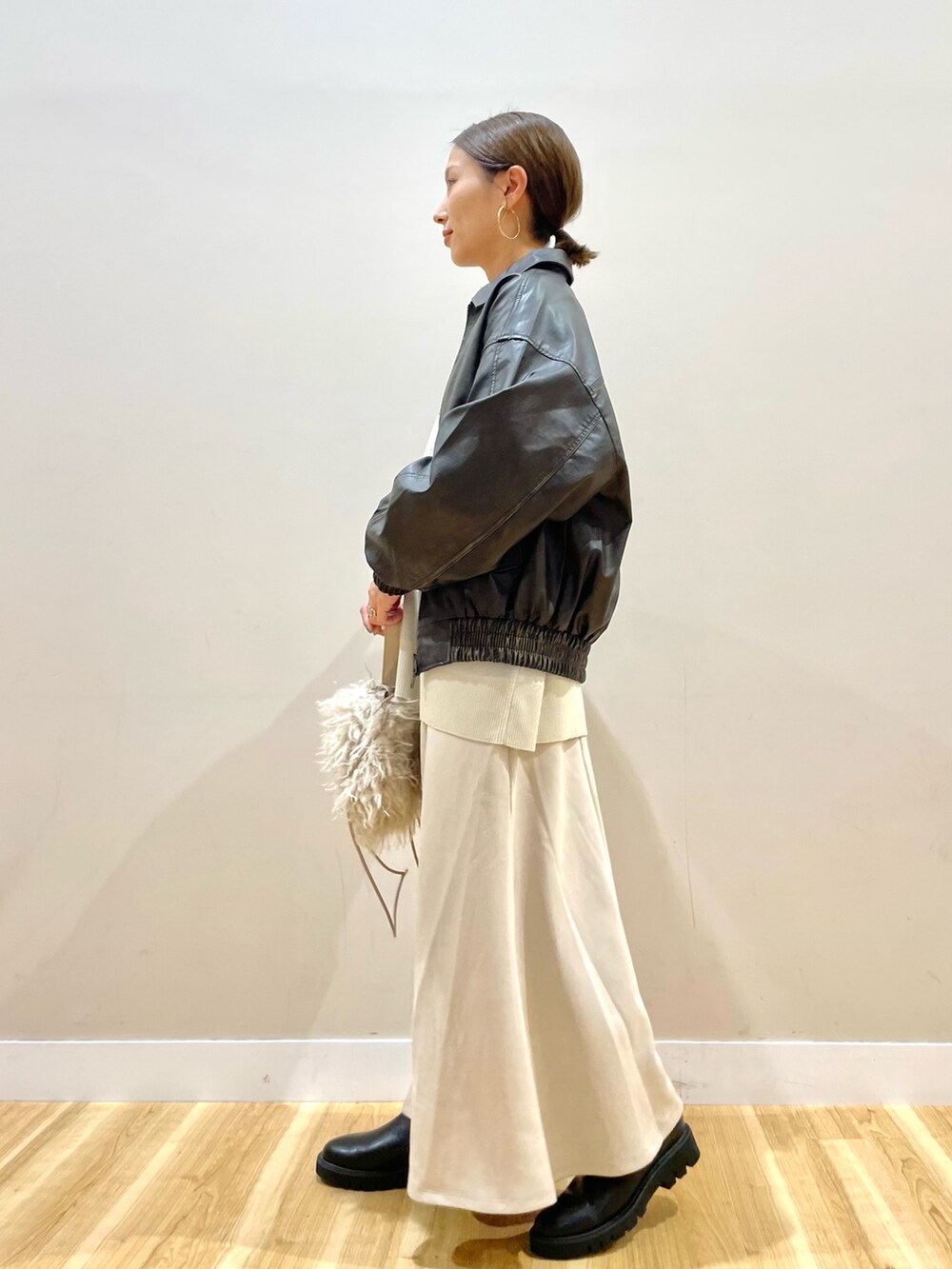 ブラウン系のその他アウター、ホワイト系のニット/セーター、ベージュ系のスカートを着用したレディースの秋コーディネートの5枚目の写真