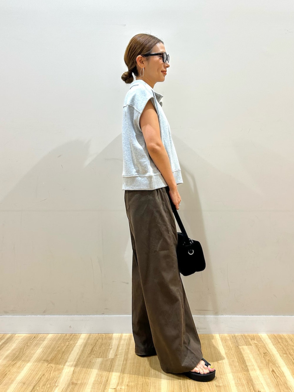 グレー系のスウェット、ブラウン系のその他パンツ、ブラック系のトートバッグを着用したレディースの夏コーディネートの2枚目の写真