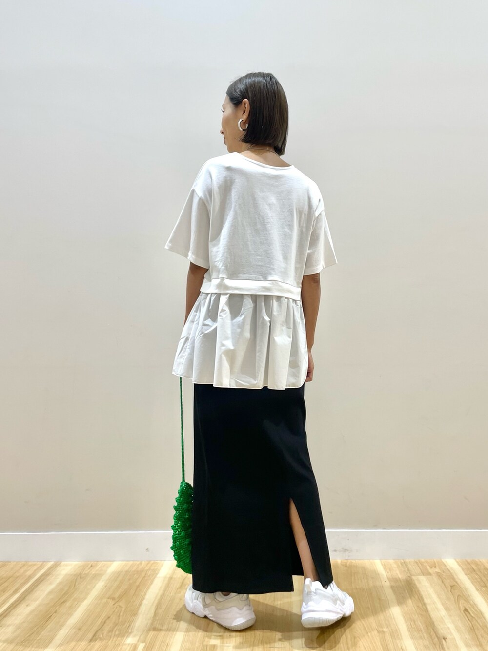 ブラック系のベスト、ホワイト系のTシャツ/カットソー、ブラック系のスカートを着用したレディースの秋コーディネートの8枚目の写真