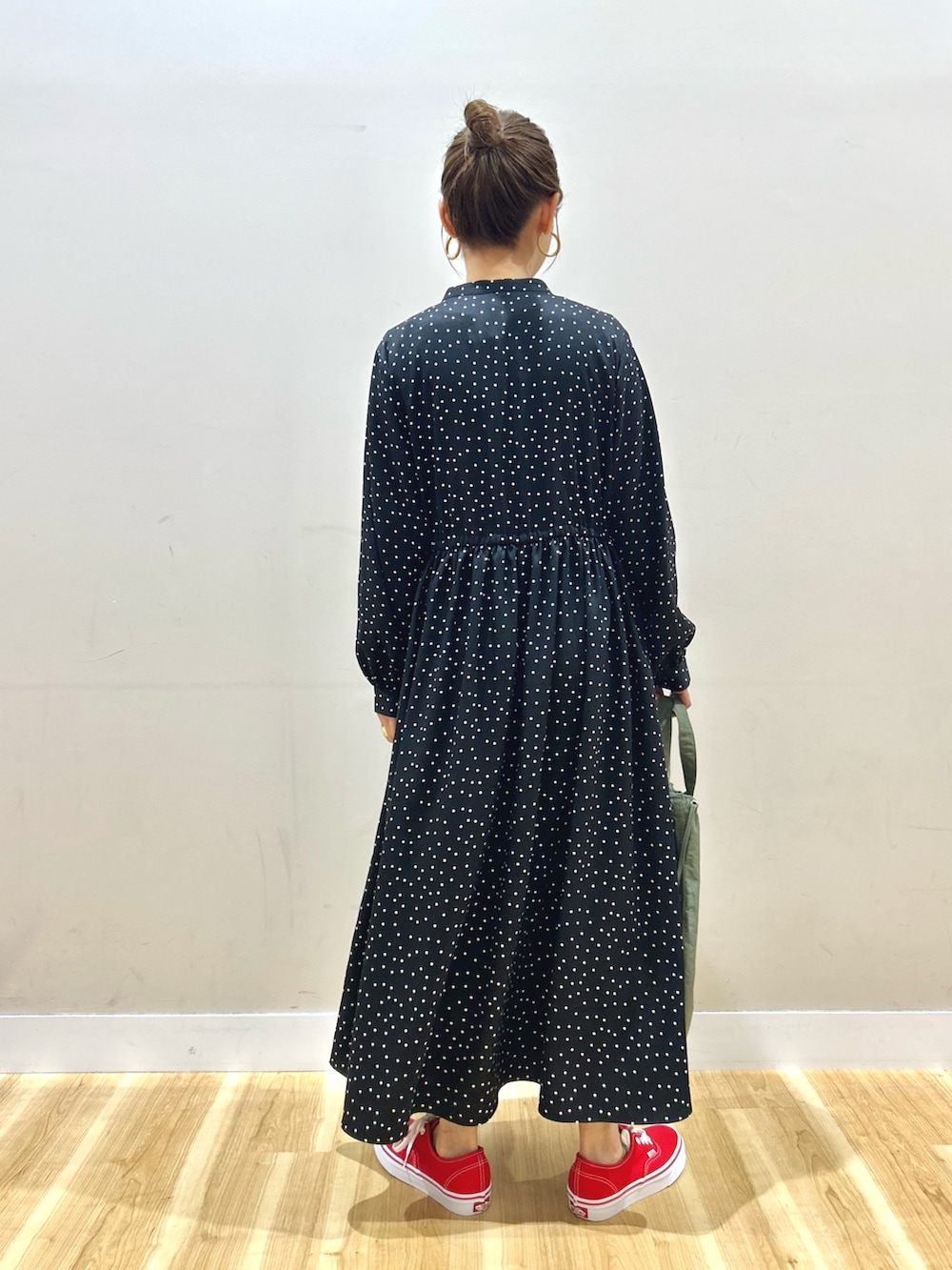 ホワイト系のマウンテンパーカー、ブラック系のワンピース、グリーン系のショルダーバッグを着用したレディースの春コーディネートの8枚目の写真