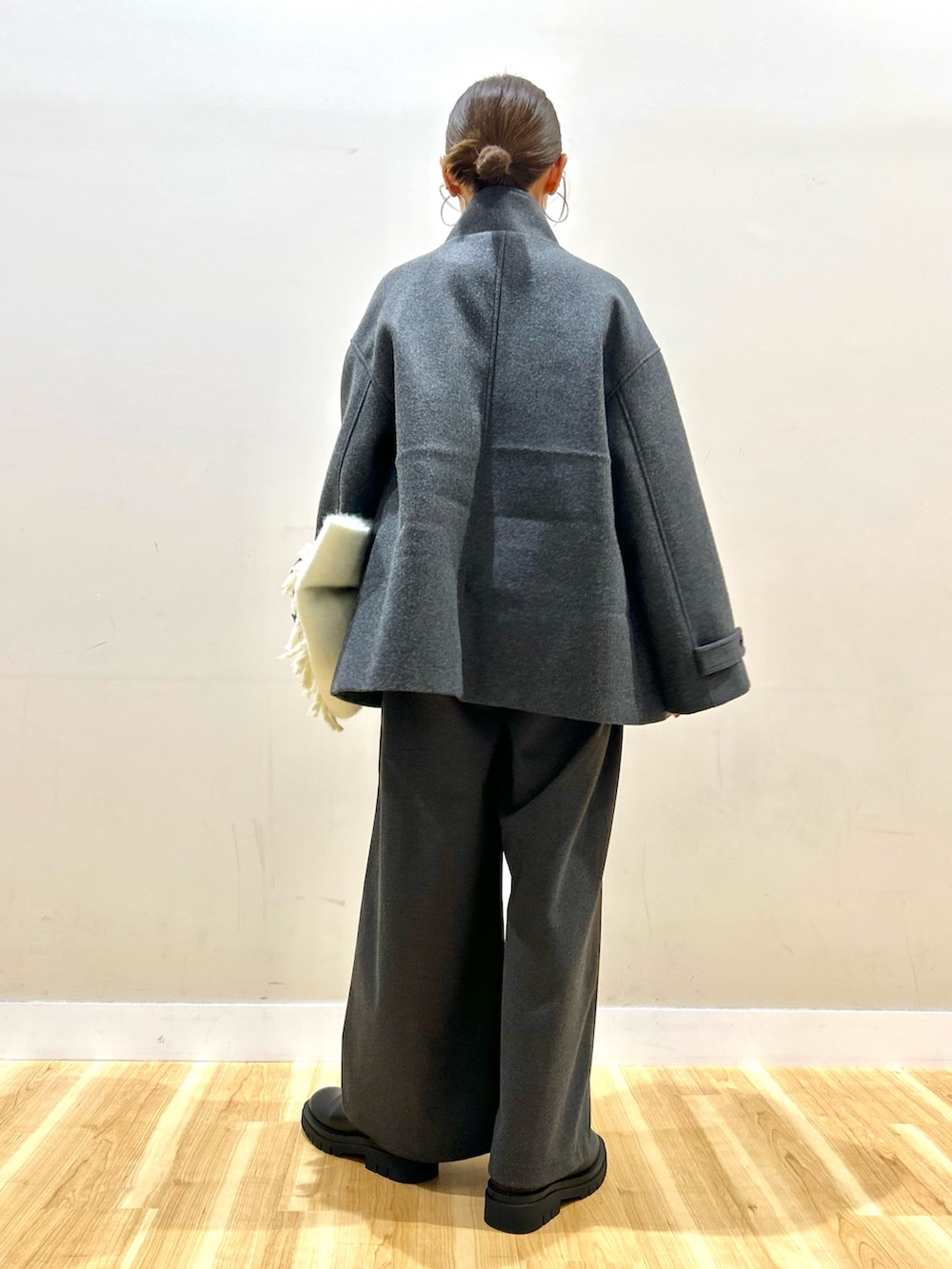 グレー系のその他アウター、ブラック系のその他パンツ、ブラック系のブーツを着用したレディースの冬コーディネートの2枚目の写真