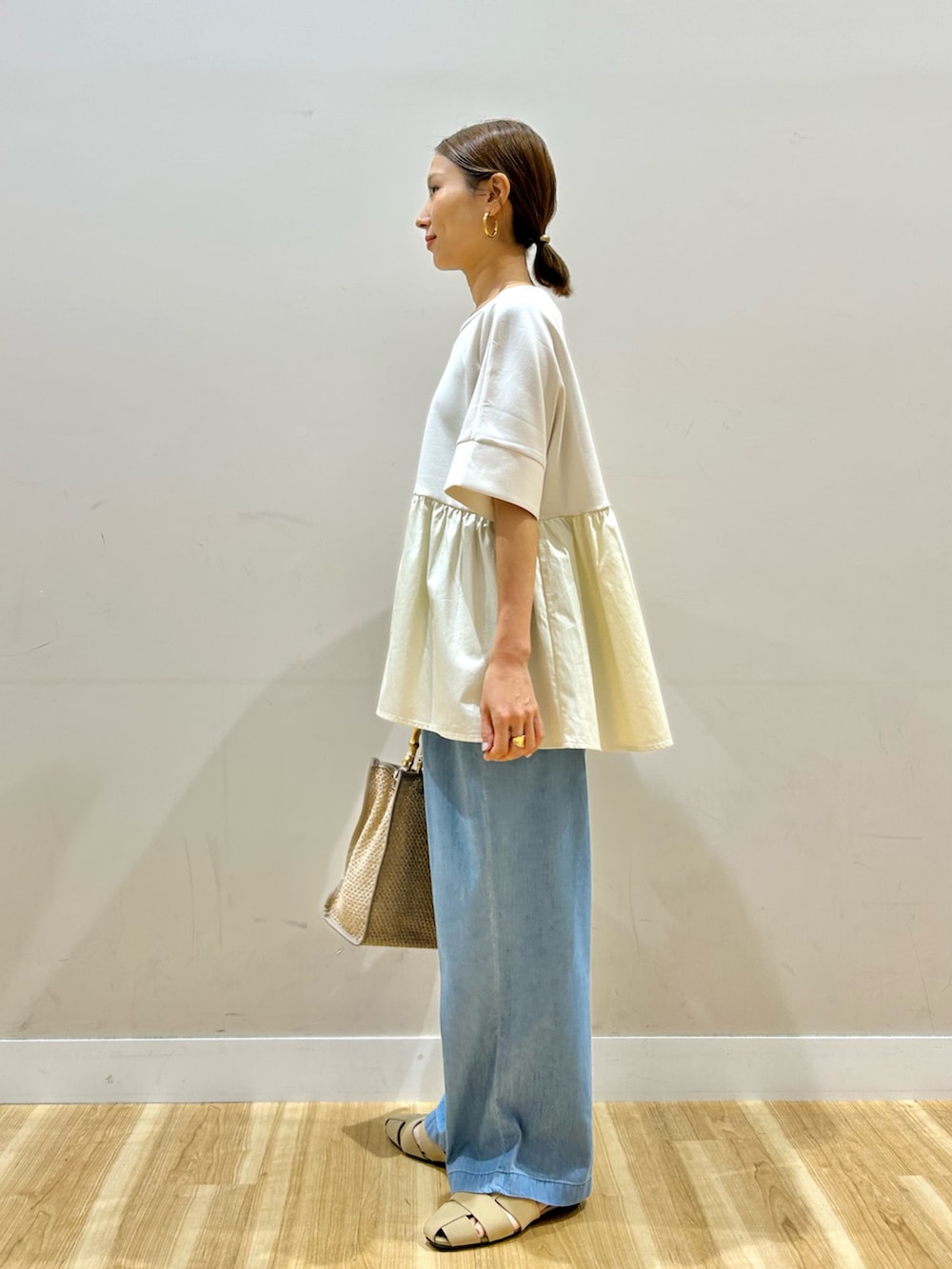 ホワイト系のTシャツ/カットソー、ブルー系のデニムパンツ、ベージュ系のサンダルを着用したレディースの夏コーディネートの3枚目の写真