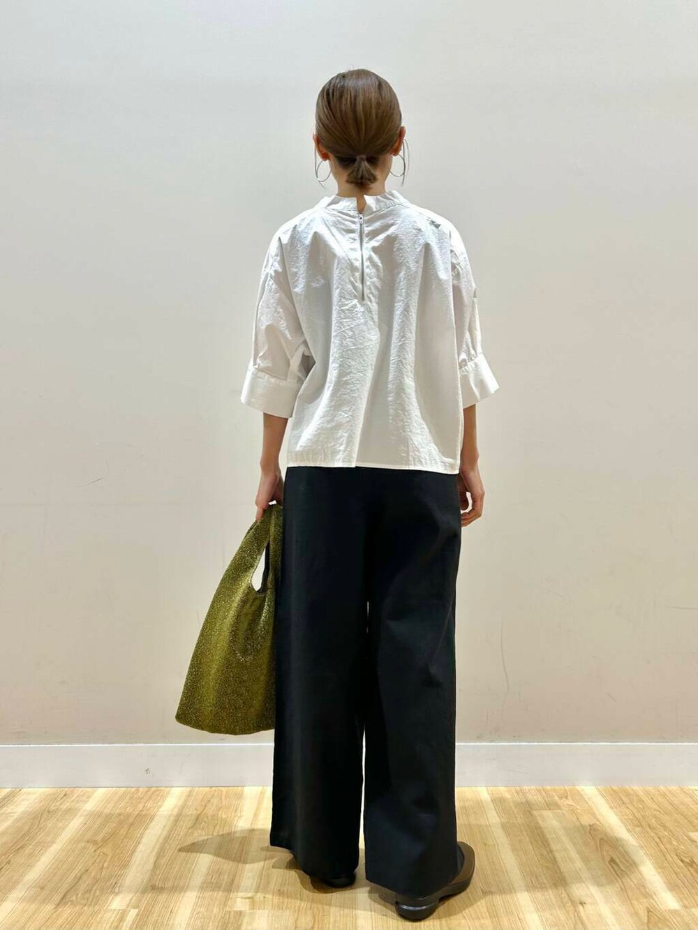 ゴールド系のトートバッグ、ブラック系のその他パンツ、ホワイト系のシャツ/ブラウスを着用したレディースの春コーディネートの3枚目の写真